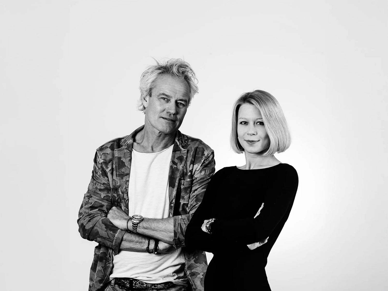 Portrait des Designer-Duos vor weißem Hintergrund – kreative Köpfe hinter handgefertigten stoffbezogenen Bilderrahmen für modernes Interior Design.