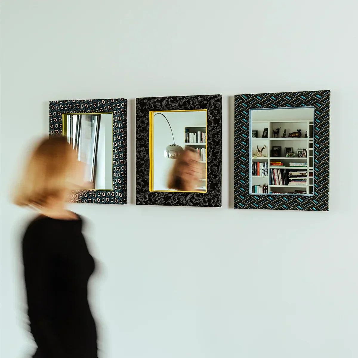 Junge Frau huscht bei 3 PIC | PUNK Spiegeln vorbei und lächelt, mit wehendem Haar