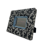 Querformatiger Bilderrahmen aus schwarzem Jacquard-Stoff mit weißem/hellgrauen Barockmuster und kontrastierendem hellblauem Inlay – eleganter Stoffrahmen für stilvolle Wohnaccessoires und Interior Design.
Für 10x15cm Fotos.