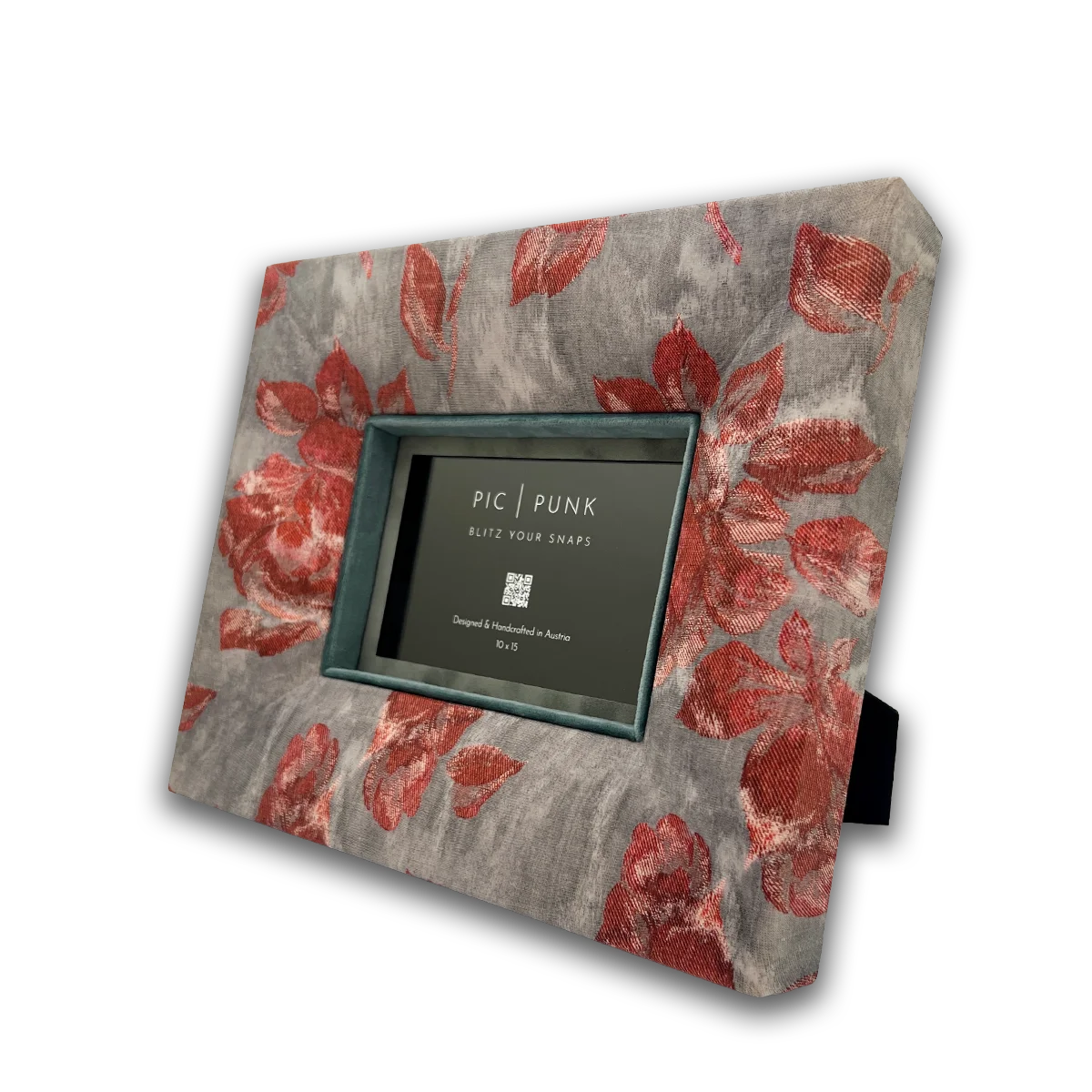 Rechteckiger Design Bilderrahmen „Concrete Rose“ – handgefertigtes Unikat von PIC | PUNK® aus Wien, grauer Stoffbezug in Betonoptik mit rotem Rosenmuster, leicht schräg fotografiert mit sichtbarer Tiefe und Schatten, moderner Designrahmen für Fotos, Kunstprints und Galeriewände.