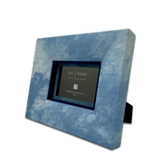 Handgefertigter Design-Bilderrahmen aus hellblauem Denim-Stoff in schräger Ansicht, mit tiefblauem Inlay und moderner, klarer Linienführung. Der Stoff-Fotorahmen „Billy Jean“ von PIC | PUNK eignet sich für Fotos im Format 10 × 15 cm und verbindet urbanen Denim-Look mit hochwertigem Interior-Design. Jedes Stück wird in Österreich von Hand gefertigt und ist ein einzigartiges Wohnaccessoire für stilvolle Wand- und Tischdekoration, moderne Wohnräume, kreative Galeriewände und besondere Geschenkideen.