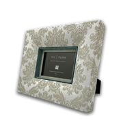 Rechteckiger Design-Bilderrahmen „East End Whisper“ von PIC | PUNK® in schräger Ansicht, edler Stoffrahmen in hellen Beigetönen mit klassischem Damastmuster, handgefertigt in Österreich, tiefer Rahmen mit farbigem Innenrand und Passepartout, hochwertiger Bilderrahmen für stilvolle Wohnräume, elegante Wandgestaltung und zeitloses Interior Design in modernen und klassischen Einrichtungen.