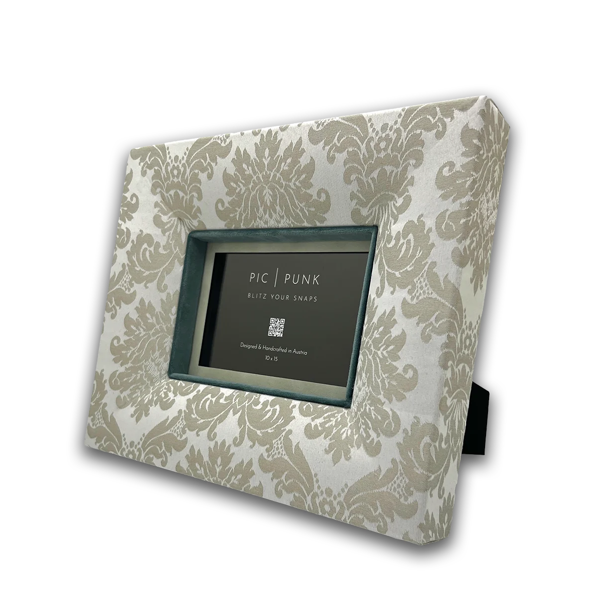 Rechteckiger Design-Bilderrahmen „East End Whisper“ von PIC | PUNK® in schräger Ansicht, edler Stoffrahmen in hellen Beigetönen mit klassischem Damastmuster, handgefertigt in Österreich, tiefer Rahmen mit farbigem Innenrand und Passepartout, hochwertiger Bilderrahmen für stilvolle Wohnräume, elegante Wandgestaltung und zeitloses Interior Design in modernen und klassischen Einrichtungen.