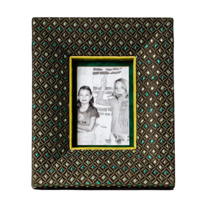 Frontansicht eines handgefertigten Stoff-Bilderrahmens in Dunkelgrün mit feinem geometrischem Muster und samtigem Innenrahmen in Apfelgrünem Samt. In dem Rahmen befindet sich ein Schwarzweißfoto von zwei Kindern. Der Design-Fotorahmen von PIC PUNK bietet eine tiefe 3D-Wirkung, ist für 10×15 cm Fotos geeignet und verbindet hochwertige Stoffe mit moderner Wohnästhetik - ein dekorativer Blickfang für Regal, Sideboard oder Wand.