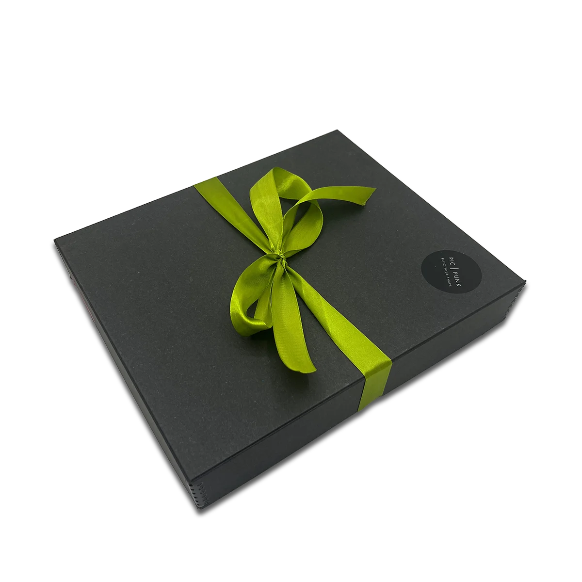 Elegante schwarze Geschenkbox mit grüner Schleife – hochwertige Verpackung für die stoffbezogenen Design-Bilderrahmen von PIC | PUNK. Ideal als stilvolles Geschenk für besondere Anlässe.