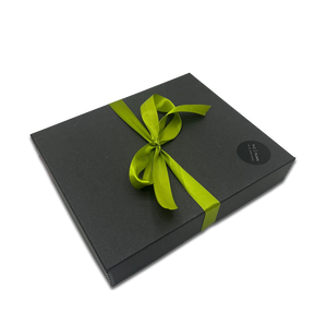 Elegante schwarze Geschenkbox mit grüner Schleife – hochwertige Verpackung für die stoffbezogenen Design-Bilderrahmen von PIC | PUNK. Ideal als stilvolles Geschenk für besondere Anlässe.