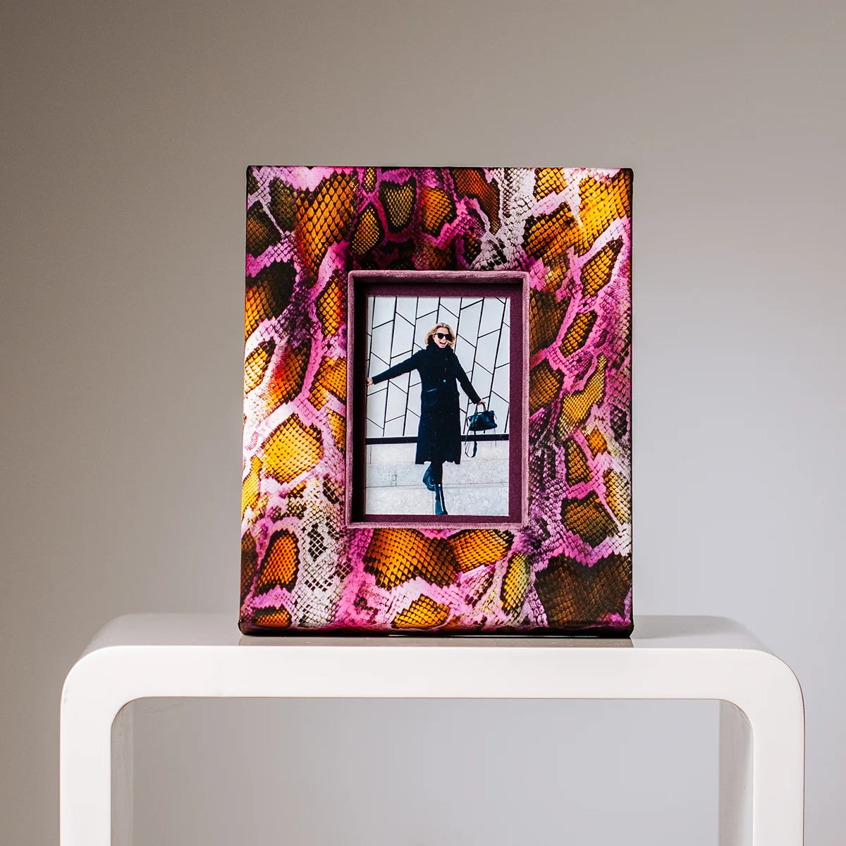 Design Bilderrahmen mit Schlangenmuster in Pink und Gelb im Interior-Setting – Hochformat, dekorativ auf weißem Tisch, handgefertigt von PIC | PUNK, für 10x15cm Fotos